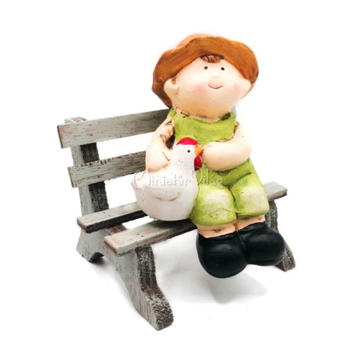 Kisfiú csirkével padon ülő figura